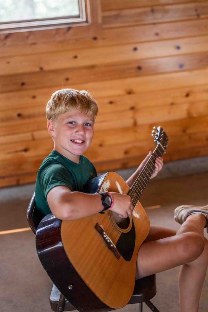 A North Star camper playing guitar