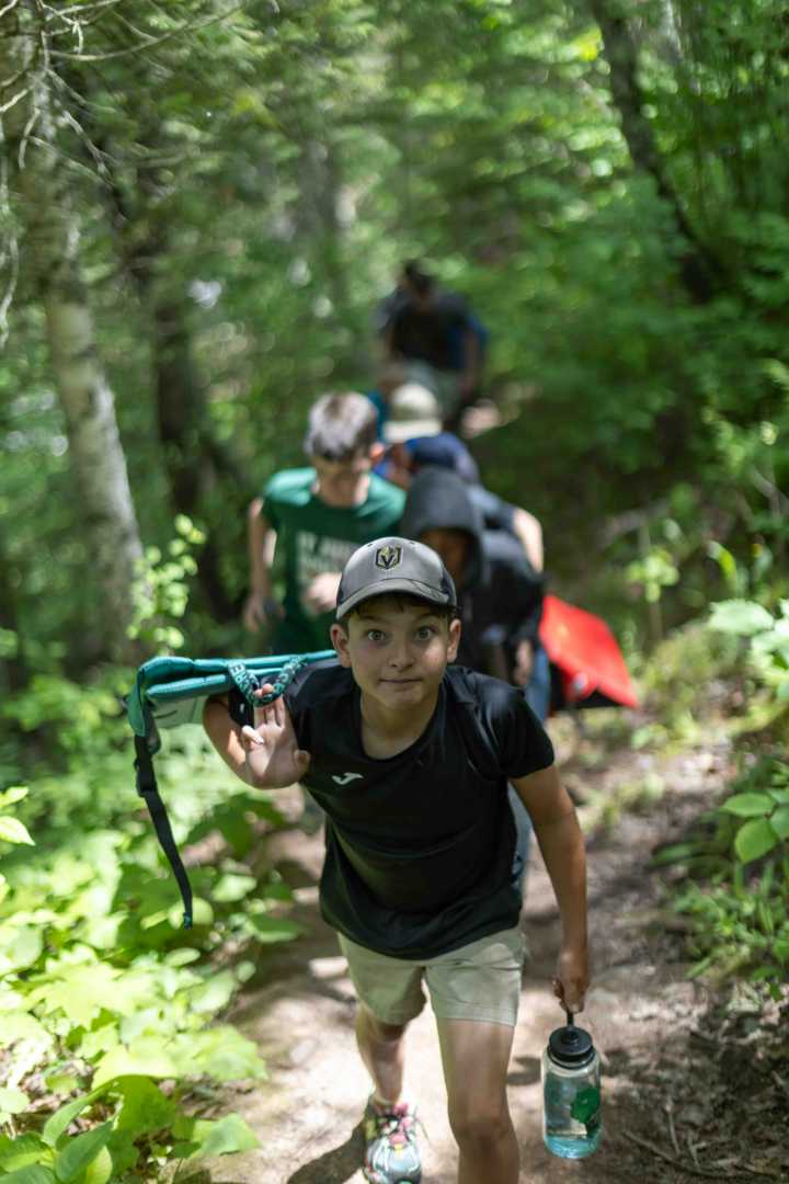 Campers hiking around the waterfalls at a Northwoods state park on a camp day trip