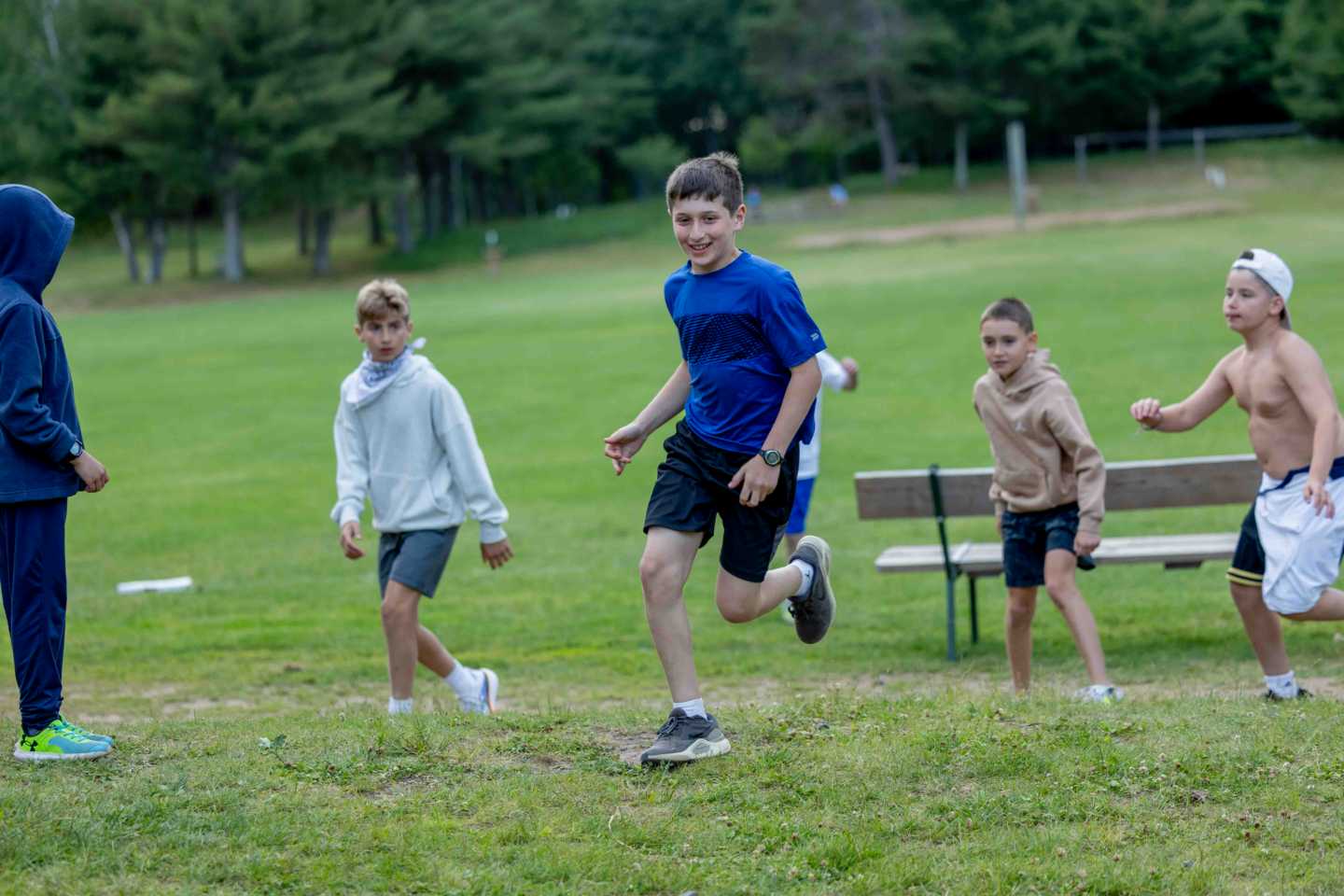 Campers playing All-Camp Capture the Flag across the fields in the evening