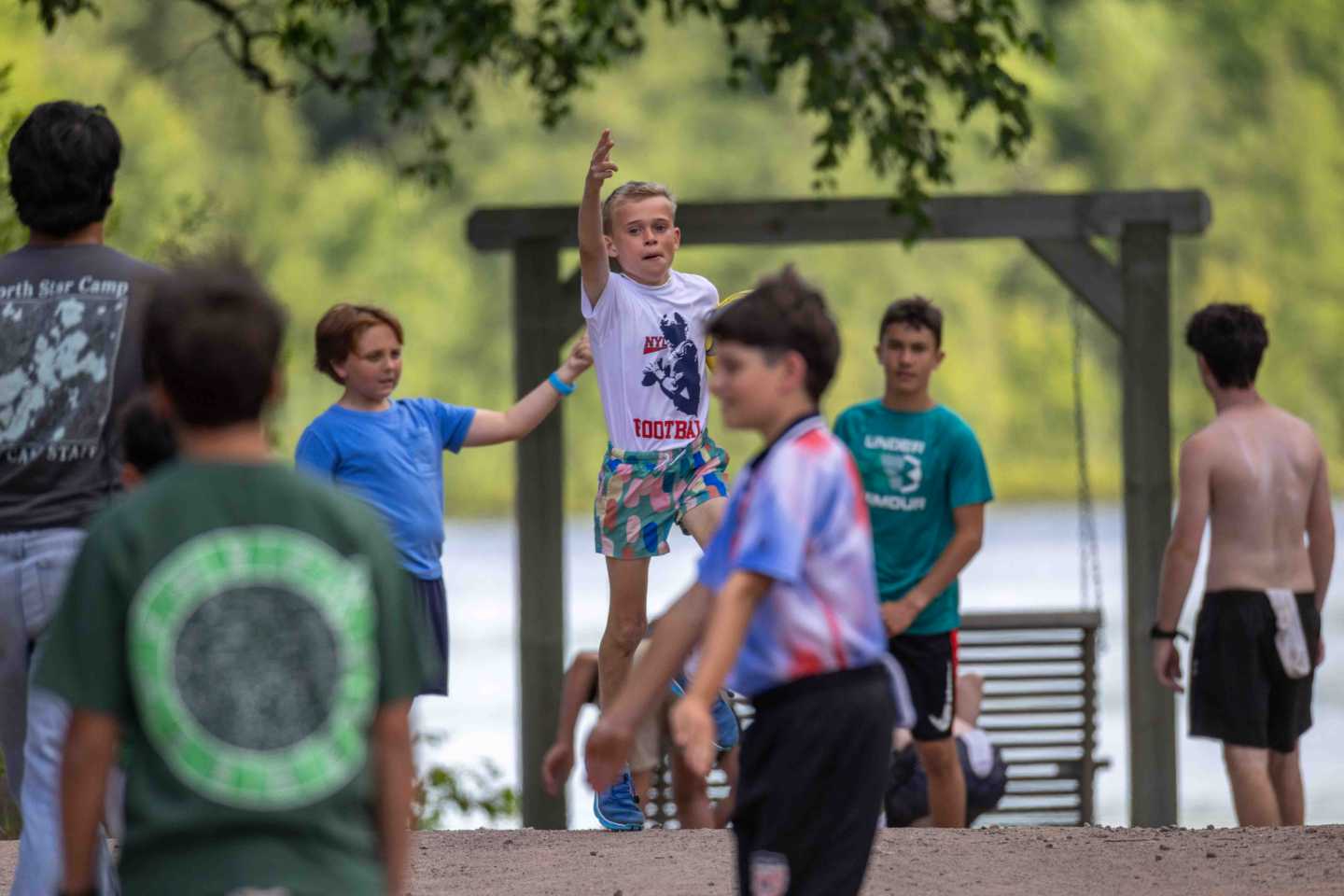 A camper leaping into the lake on a summer day at camp