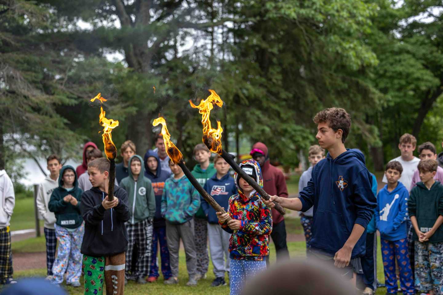 Torches lit for the Green and White team competition at summer camp