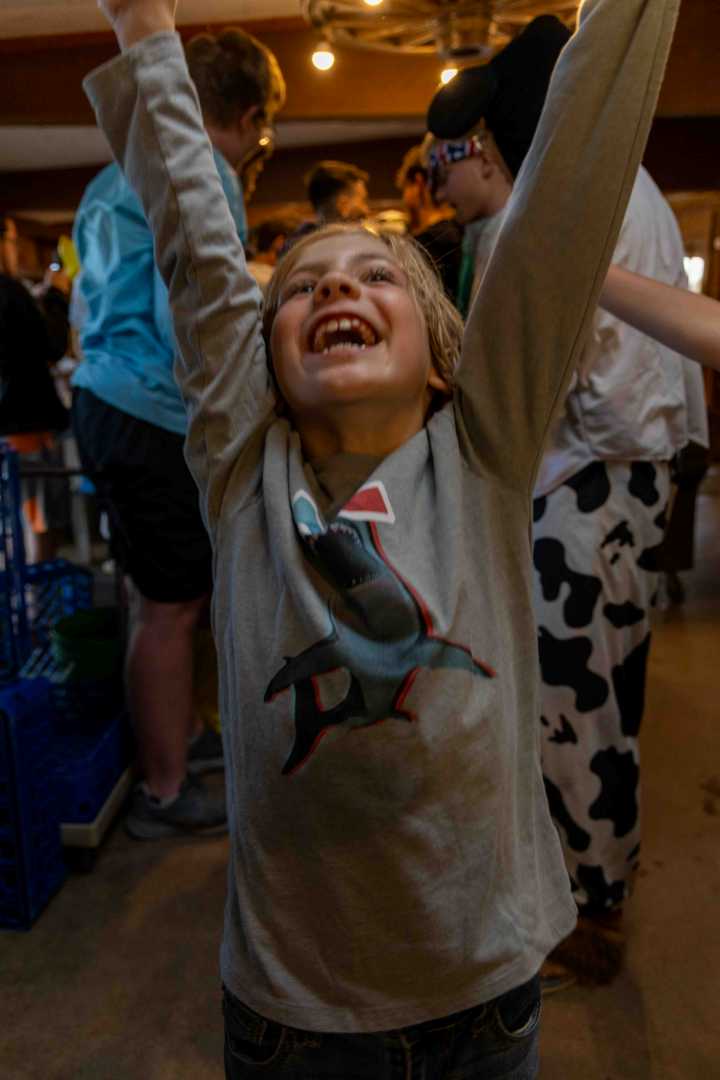 A camper at the lakefront celebrating after completing his swim test.